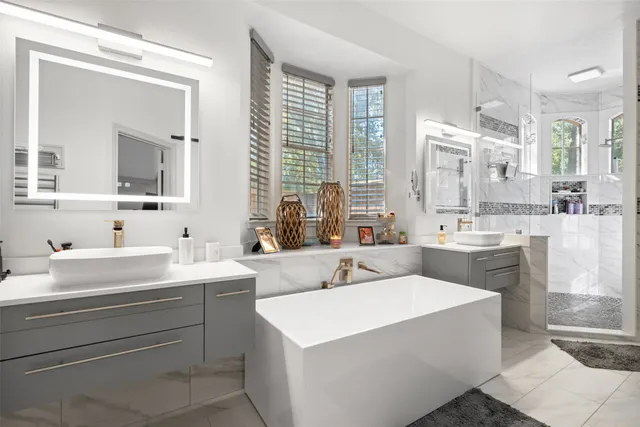 a bathroom with a double vanity sink a mirror and a bathtub