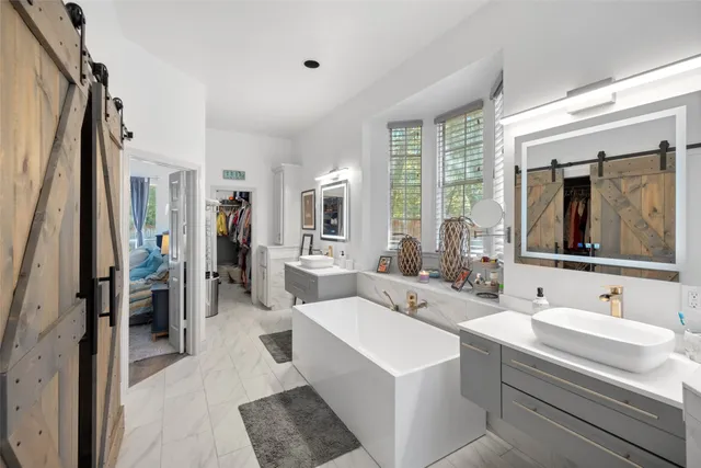 a large white room with a large window and stainless steel appliances