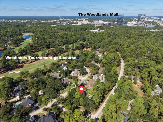 an aerial view of residential houses with outdoor space and trees