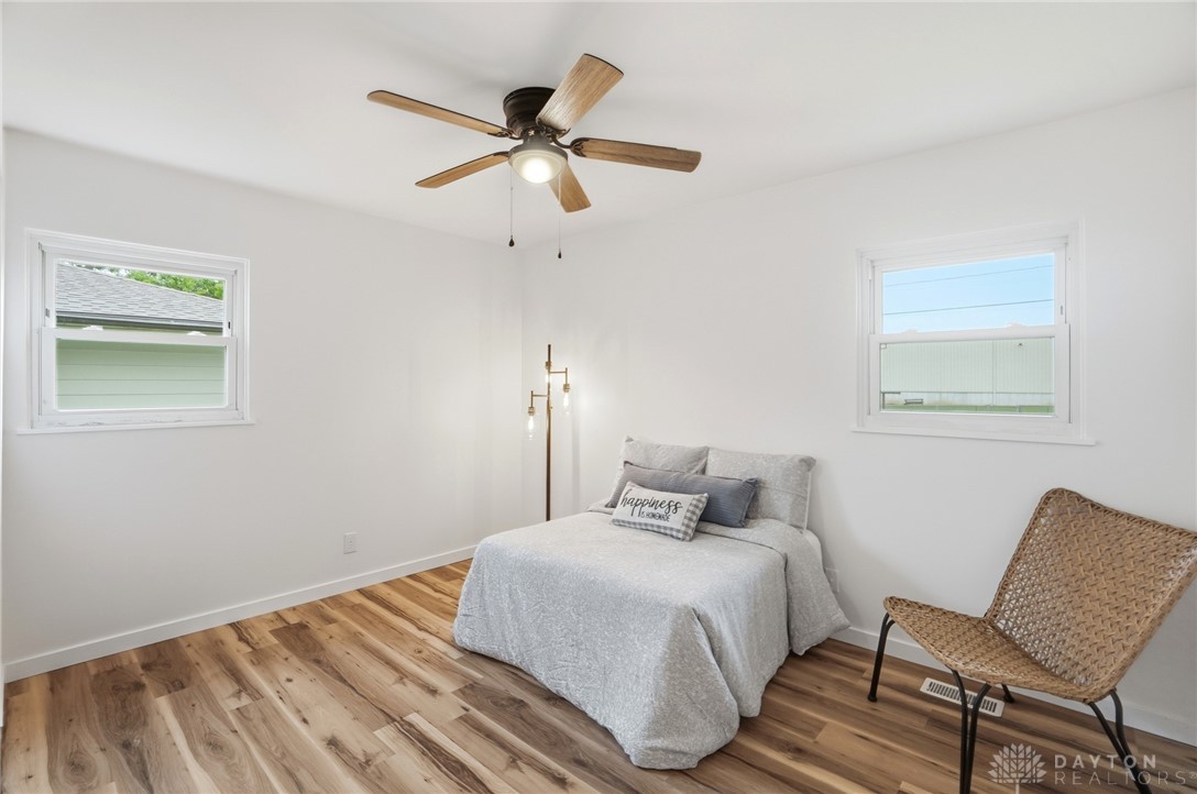 1923 Portage Path Springfield, OH 45506 - Photo 22 of 40 Brightly lit bedroom with warm wood-tone flooring and a functional ceiling fan.
