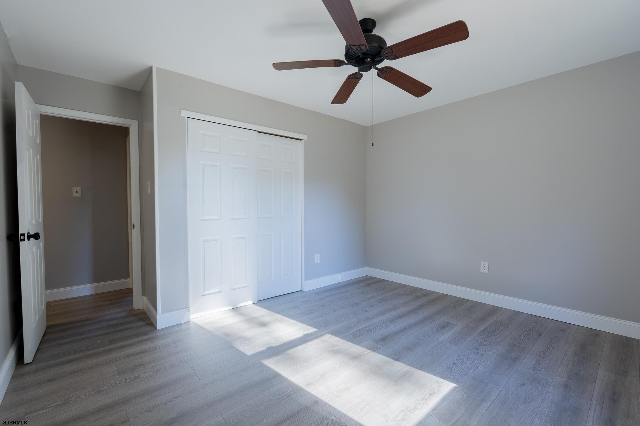 1137 South Beecham Road Williamstown, NJ 08094 - Photo 29 of 47 an empty room with wooden floor and a ceiling fan