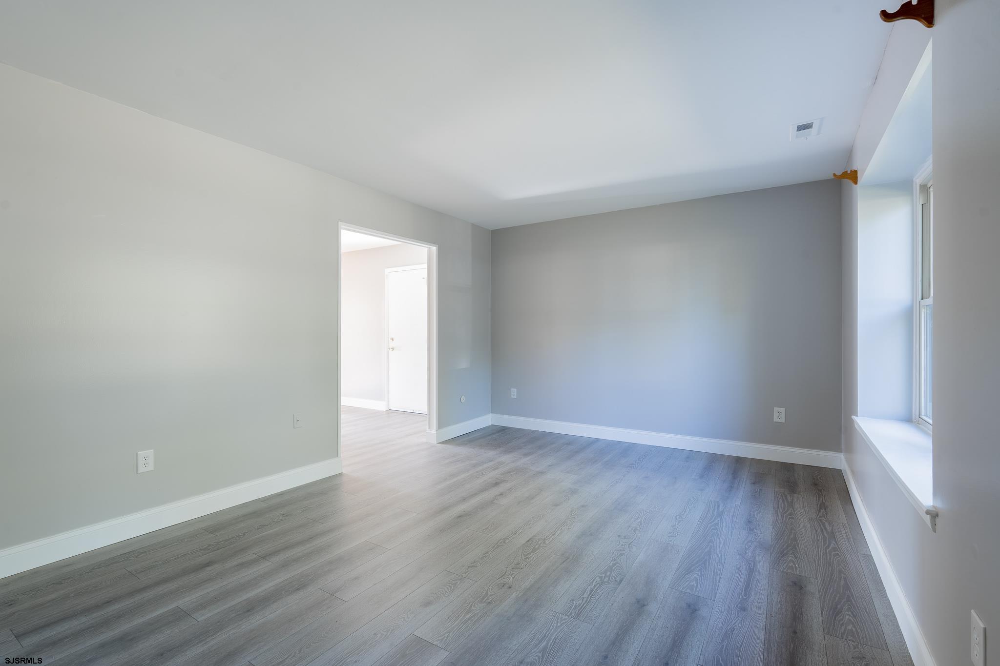1137 South Beecham Road Williamstown, NJ 08094 - Photo 7 of 47 a view of an empty room with wooden floor and a window