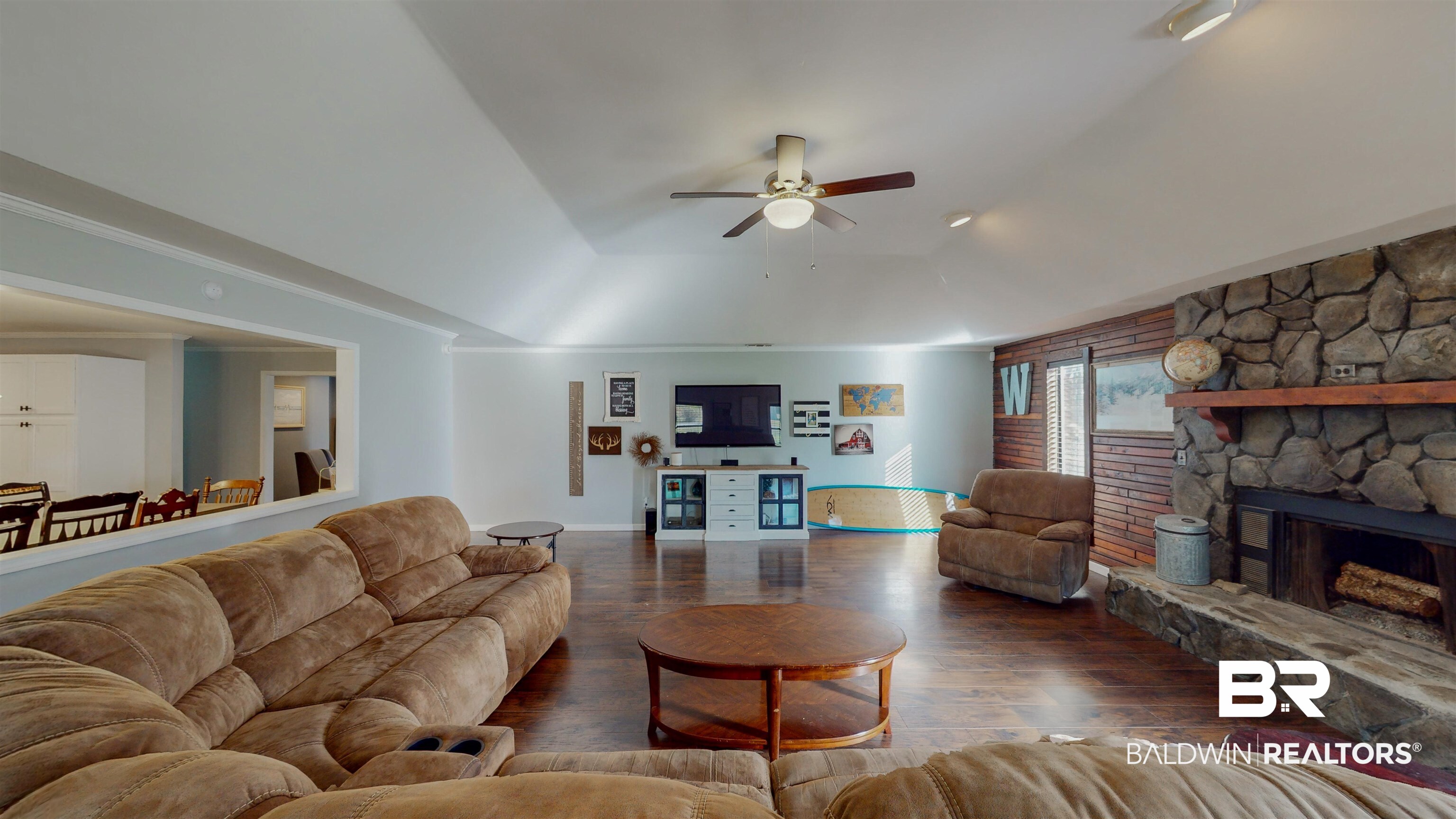 19365 Keller Road Foley, AL 36535 - Photo 15 of 41 Living room with ceiling fan, dark wood-type flooring, a stone fireplace, and a tray ceiling