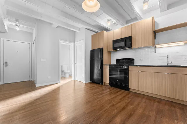 a kitchen with stainless steel appliances a refrigerator and a stove top oven