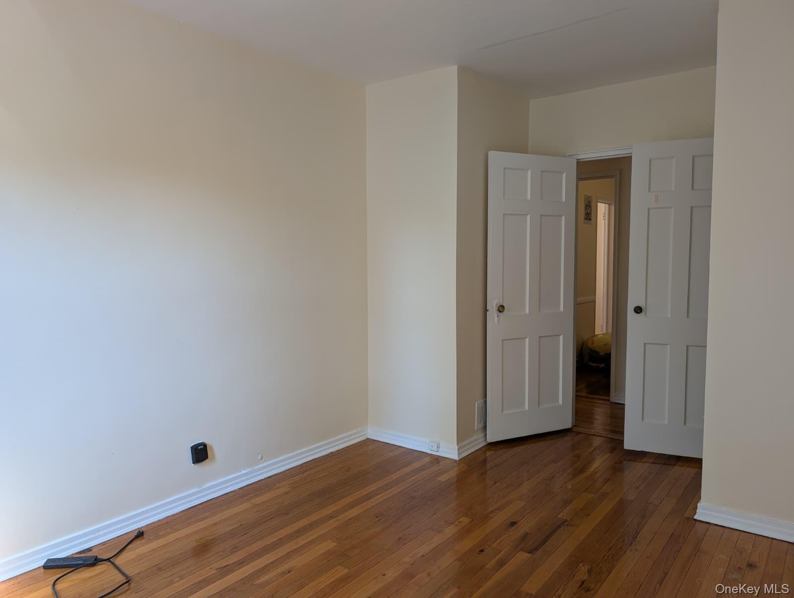 Spare room featuring baseboards and hardwood / wood-style flooring