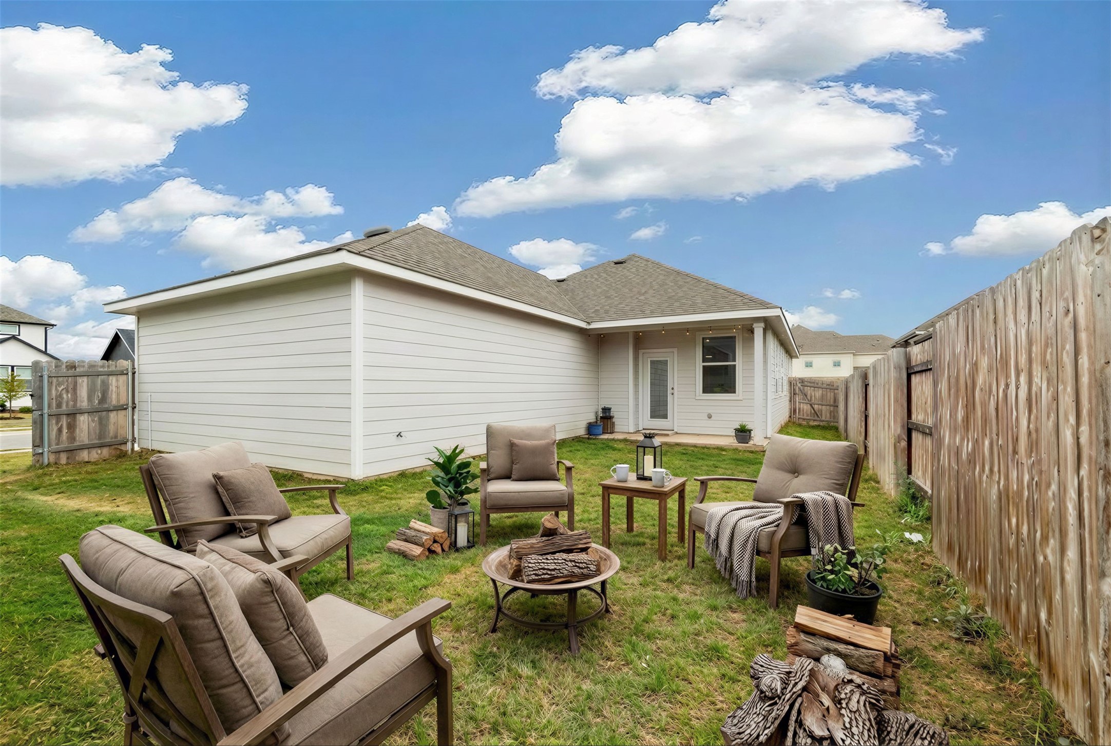 171 Acadia Drive Kyle, TX 78640 - Photo 2 of 26 Virtually staged - View of back of home with a fenced backyard, a patio, roof with shingles, an outdoor fire pit, and a gate