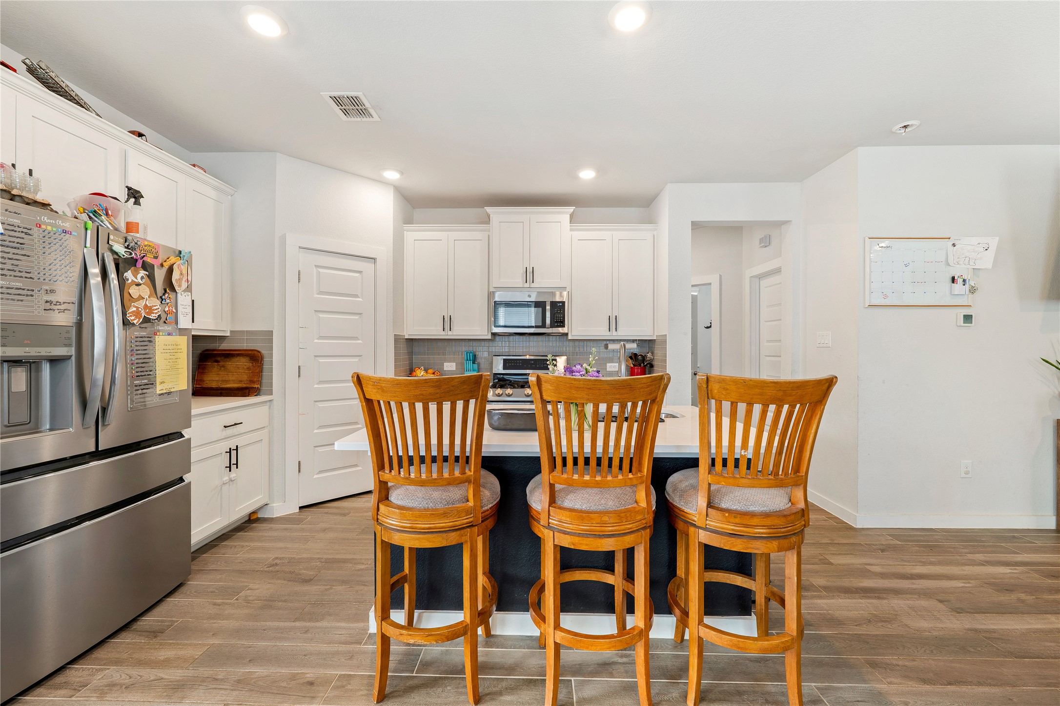 171 Acadia Drive Kyle, TX 78640 - Photo 6 of 26 Kitchen with stainless steel appliances, white cabinetry, a kitchen island with sink, and recessed lighting
