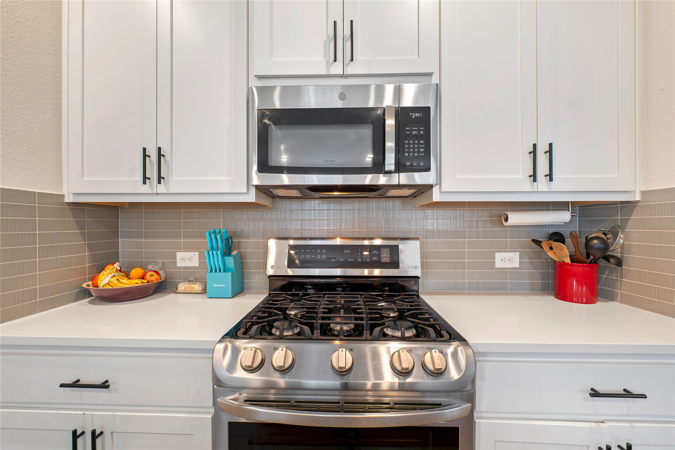 171 Acadia Drive Kyle, TX 78640 - Photo 8 of 26 Kitchen with stainless steel appliances, white cabinets, and tasteful backsplash