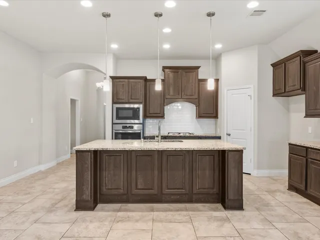 a large kitchen with stainless steel appliances a sink and counter space