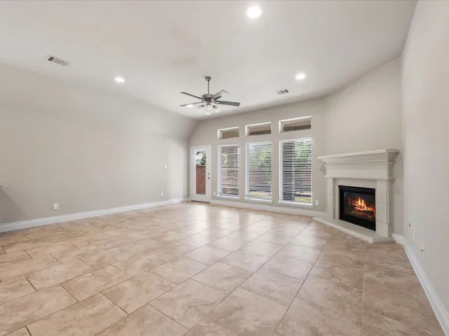 a view of an empty room with a fireplace and a window