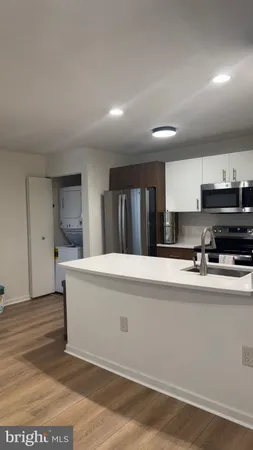 a large white kitchen with stainless steel appliances granite countertop a sink and cabinets