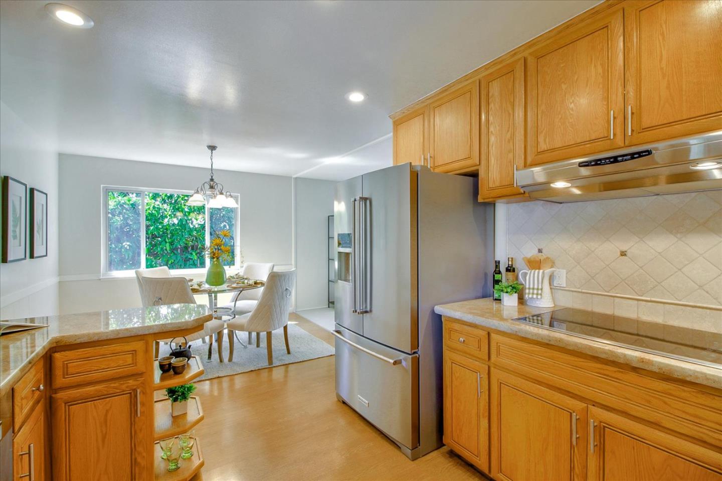 2891 Benjamin Avenue San Jose, CA 95124 - Photo 14 of 31 a kitchen with stainless steel appliances granite countertop a refrigerator a sink dishwasher a dining table and chairs with wooden floor