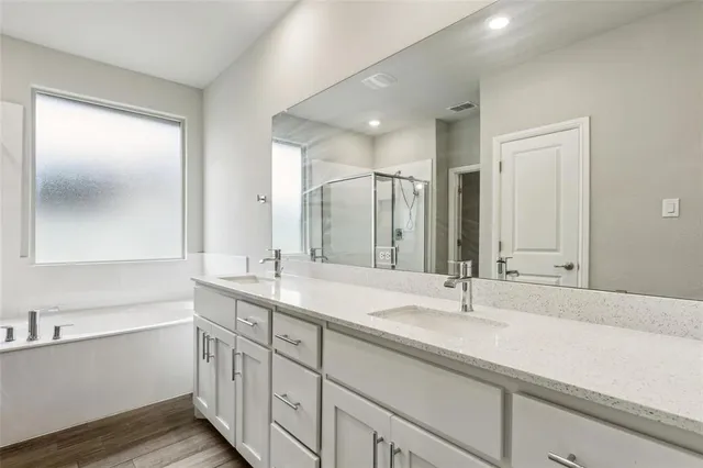 a bathroom with double vanity sinks and a mirror