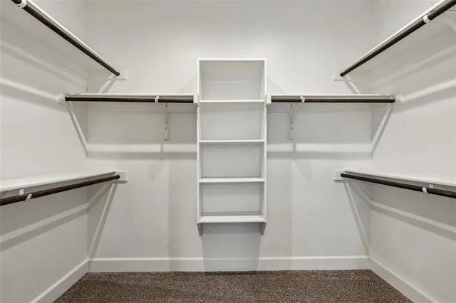 a view of walk in closet with empty racks