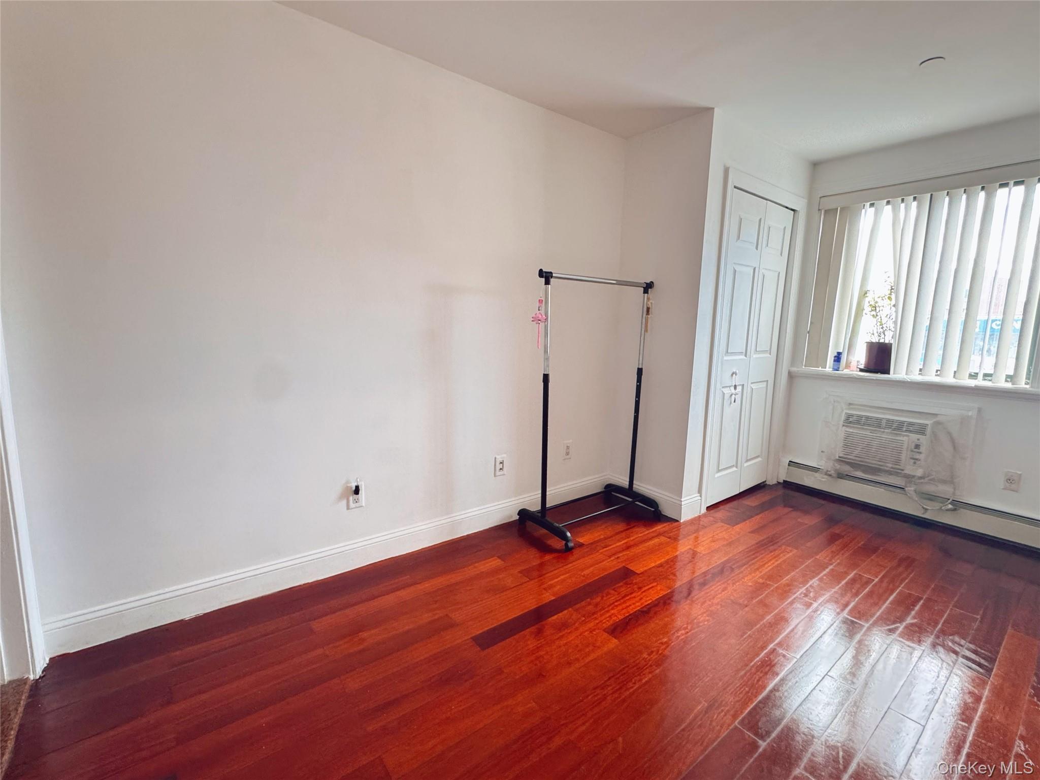 41-05 College Point Boulevard, Unit 3 Queens, NY 11355 - Photo 2 of 7 an empty room with wooden floor and windows