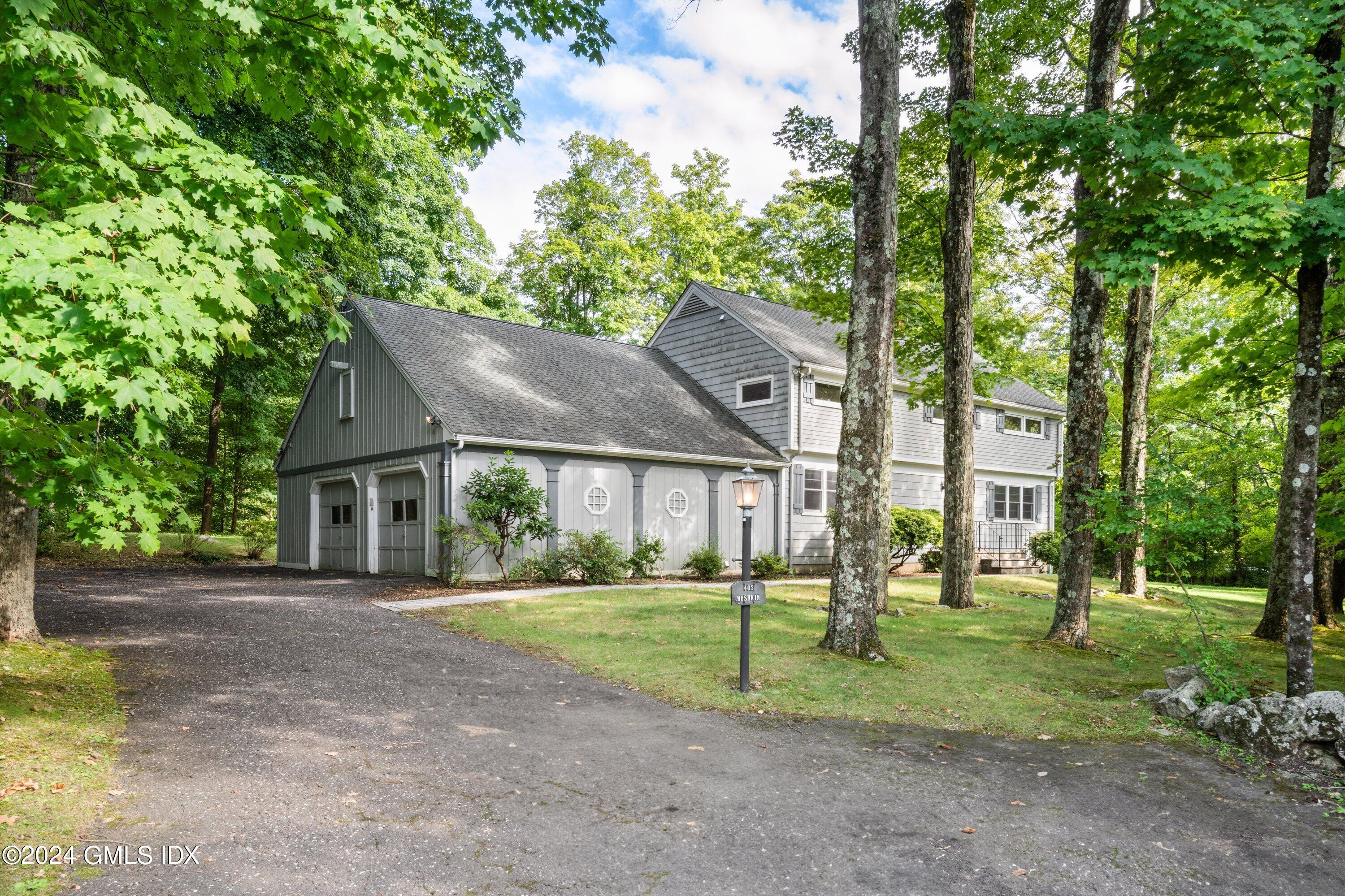 a view of a big house with a big yard and large trees