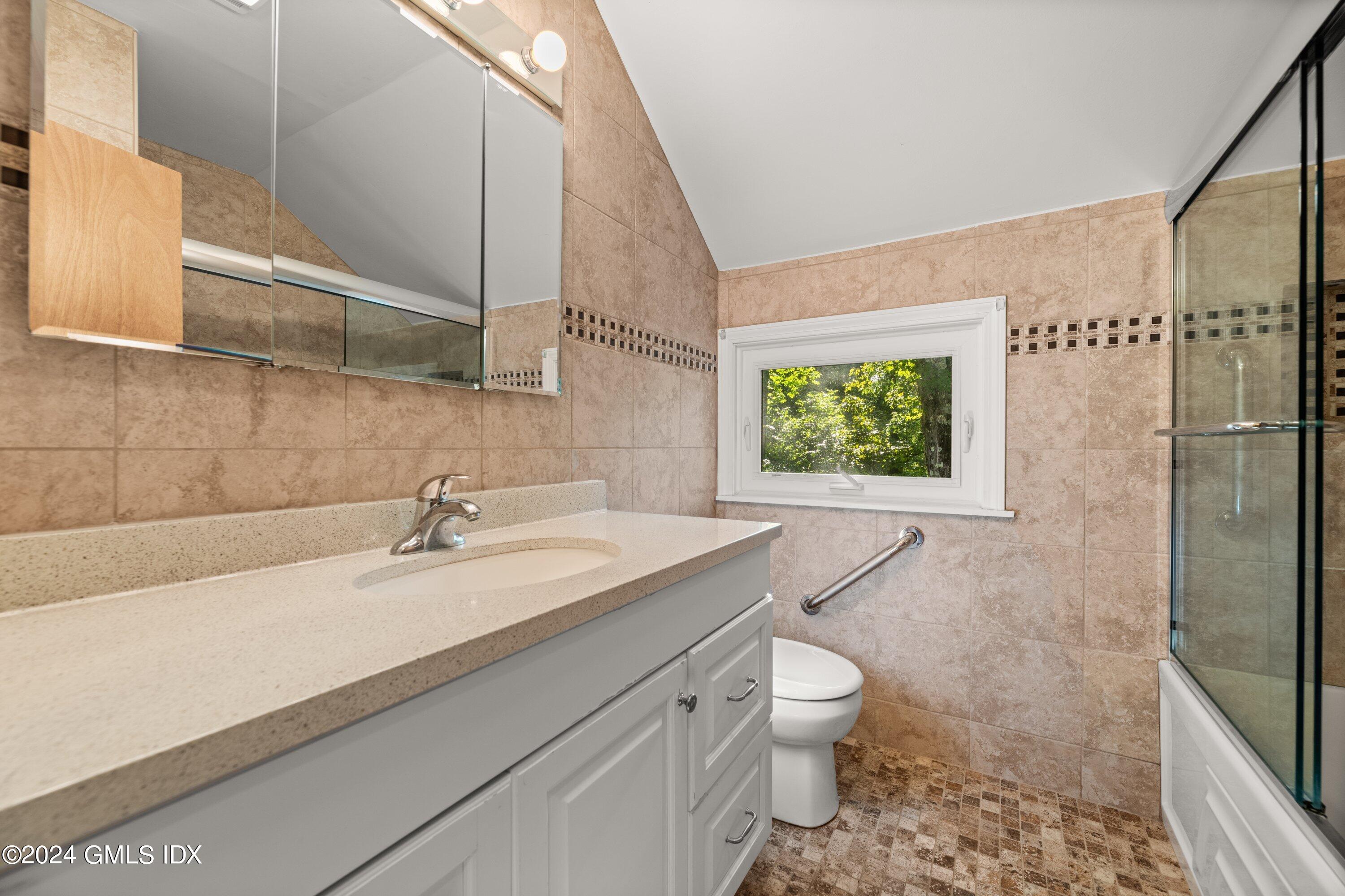 403 Stanwich Road Greenwich, CT 06830 - Photo 14 of 18 a bathroom with a granite countertop sink a toilet a mirror and shower