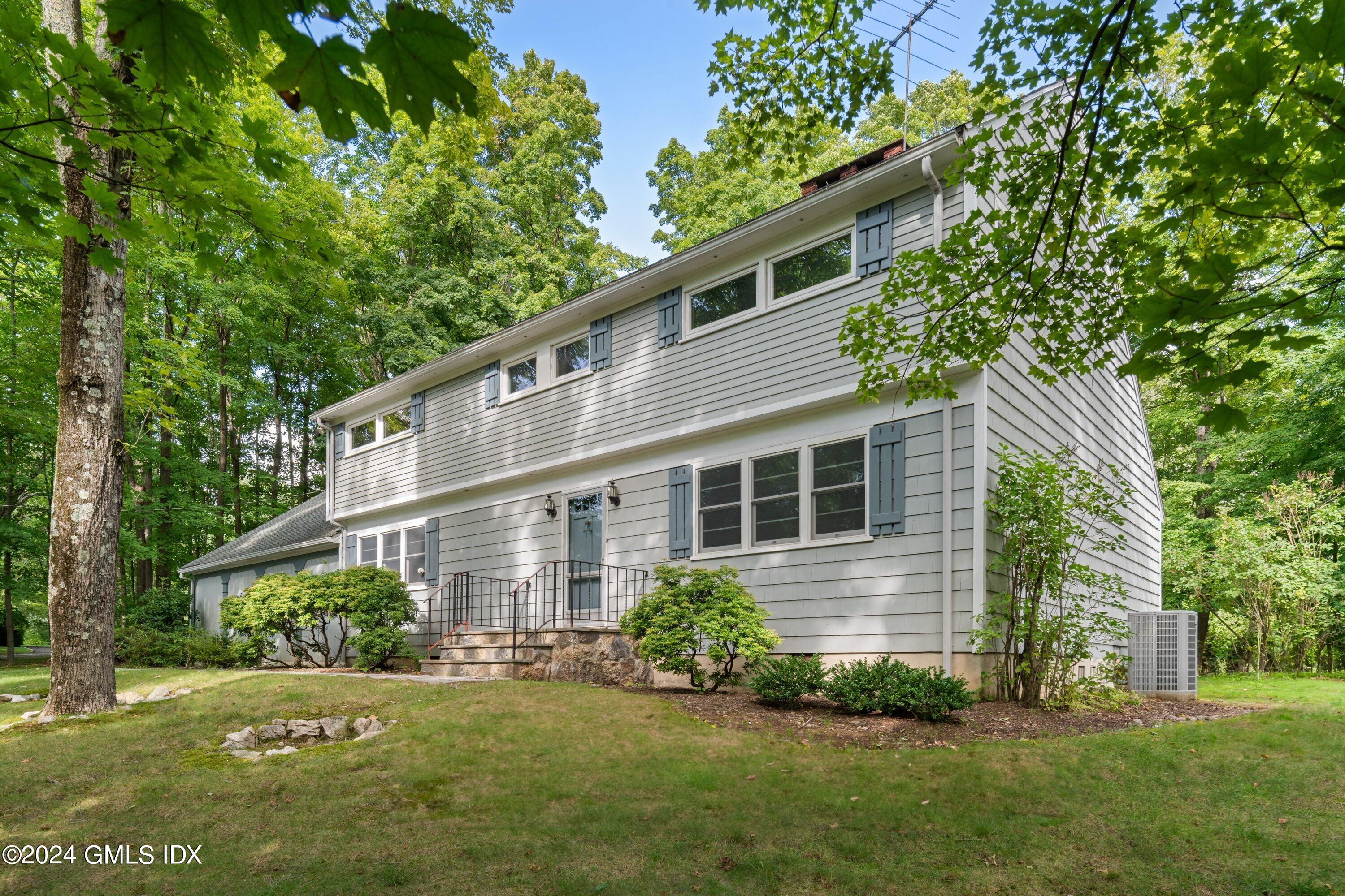 403 Stanwich Road Greenwich, CT 06830 - Photo 2 of 18 a front view of a house with a yard