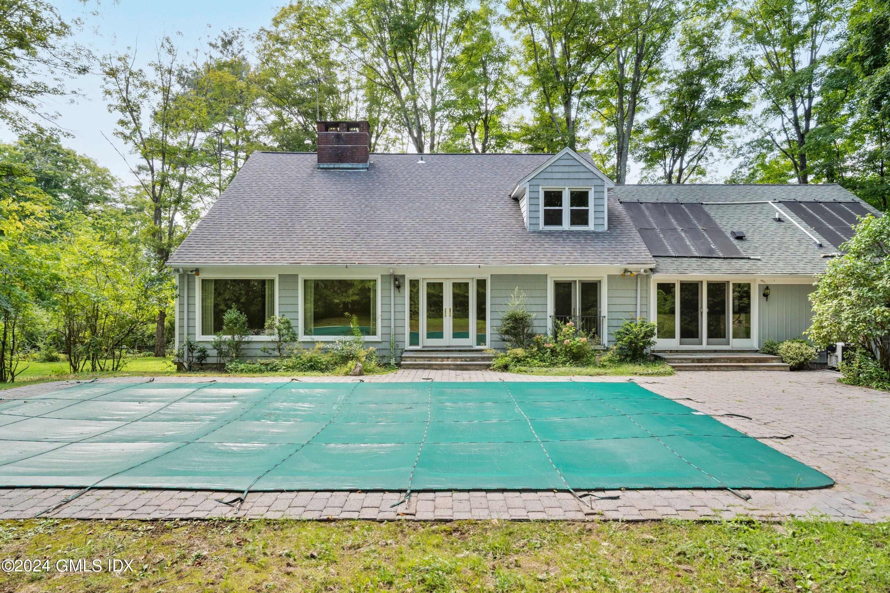 403 Stanwich Road Greenwich, CT 06830 - Photo 3 of 18 a front view of a house with a yard table and chairs