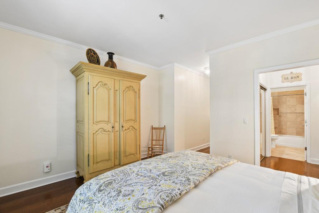 2921 Lenox Road Northeast, Unit 103 Atlanta, GA 30324 - Photo 27 of 37 a bedroom with a bed and wooden floor
