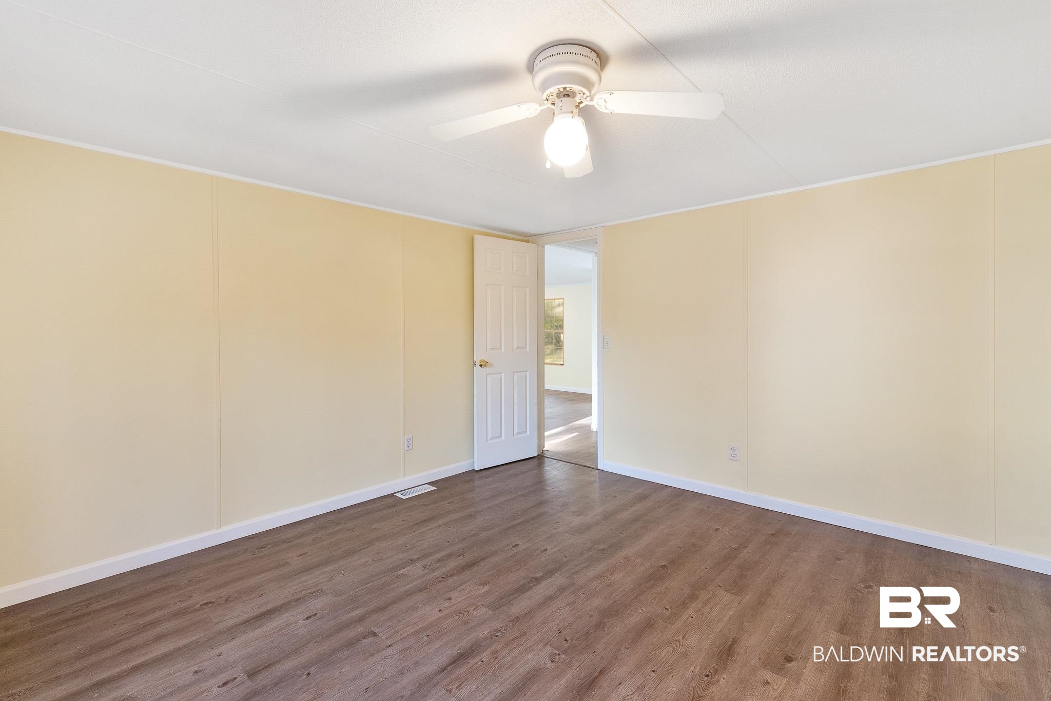 7695 Bermuda Drive Semmes, AL 36575 - Photo 21 of 27 Unfurnished room with baseboards, a ceiling fan, and wood finished floors
