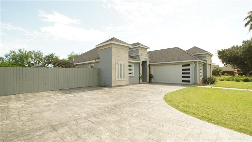 414 Ric Mar Street Edinburg, TX 78541 - Photo 1 of 36 Contemporary stucco exterior with contrasting trim, a stamped concrete driveway, and a two-car garage with modern frosted glass panels