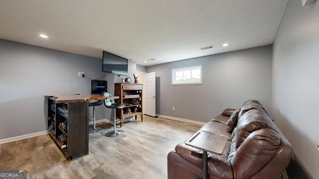 a view of backyard with table and chairs under an umbrella with large trees