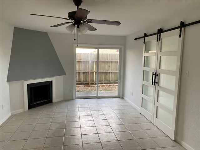 a view of an empty room with a fireplace and a window