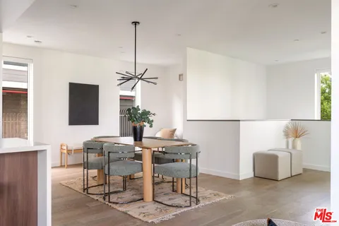 a living room with furniture a large window and a dining table