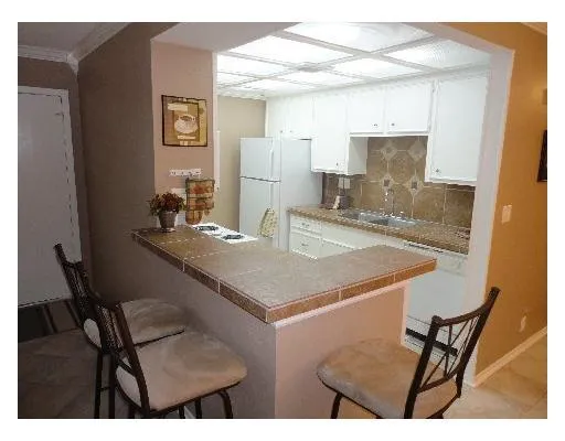 a kitchen with a table chairs and refrigerator