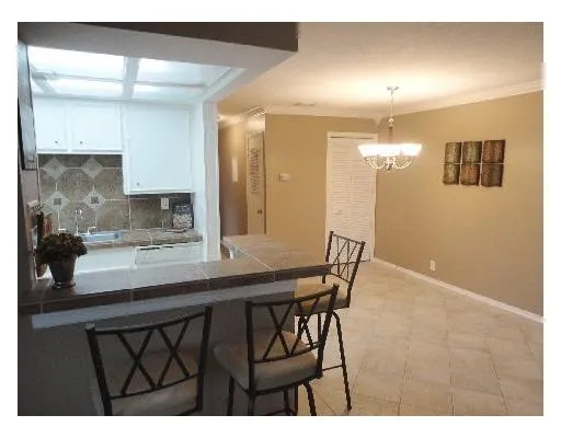 a kitchen with a table chairs refrigerator and sink