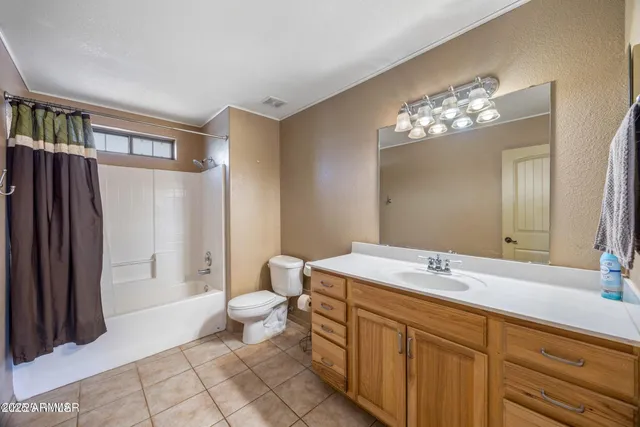 a spacious bathroom with a double vanity sink a toilet and a mirror