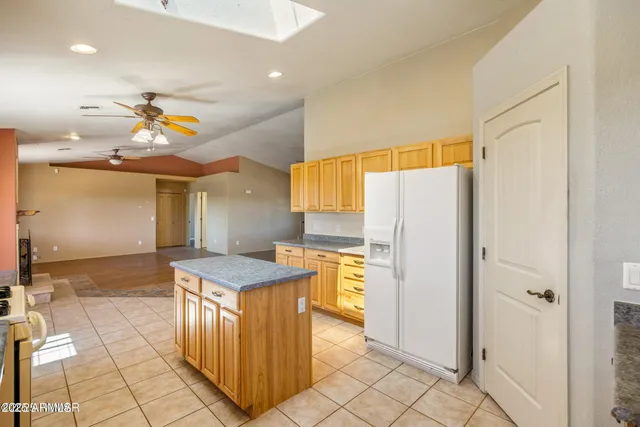 a kitchen with stainless steel appliances granite countertop a refrigerator a sink and a stove