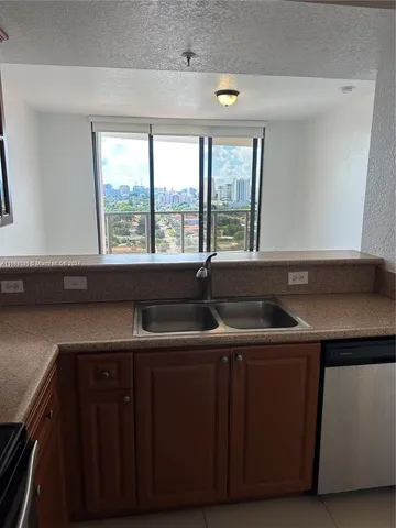 a view of a kitchen with a sink and a window