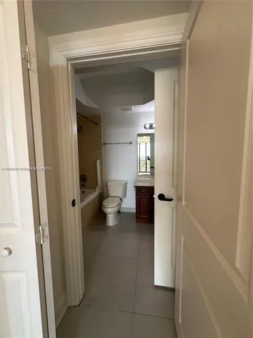 a view of a hallway with living room and bathroom