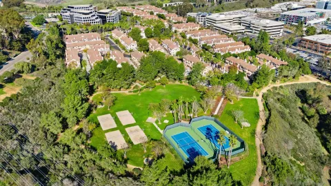 an aerial view of a house with a swimming pool a yard and a garage