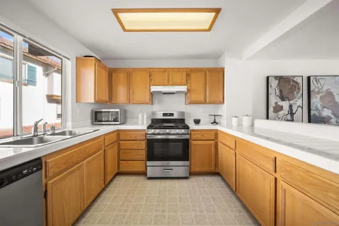 a kitchen with stainless steel appliances a stove sink and cabinets