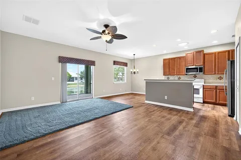 a view of a kitchen with a sink dishwasher cabinets and wooden floor