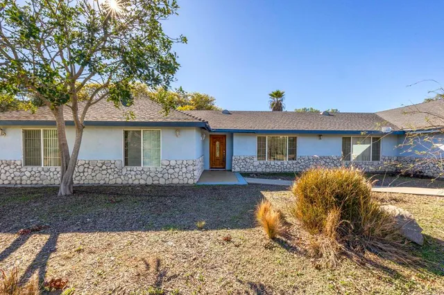 a front view of a house with a yard and outdoor seating
