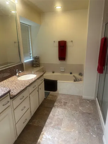 a spacious bathroom with a sink a mirror and a bathtub