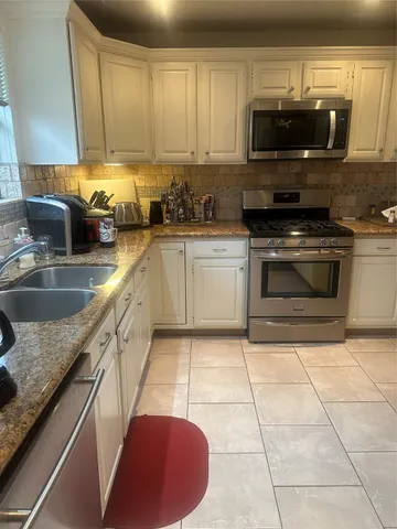 a kitchen with a sink a stove and microwave