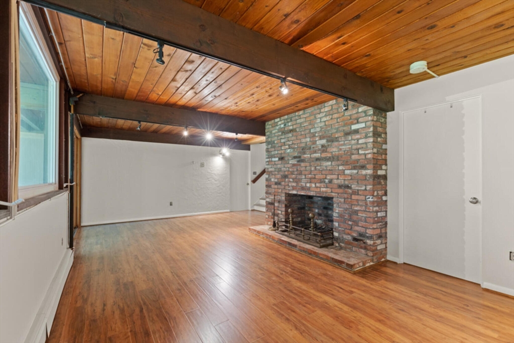 15 Pilgrims Path Sudbury, MA 01776 - Photo 18 of 29 a view of empty room with wooden floor and fireplace