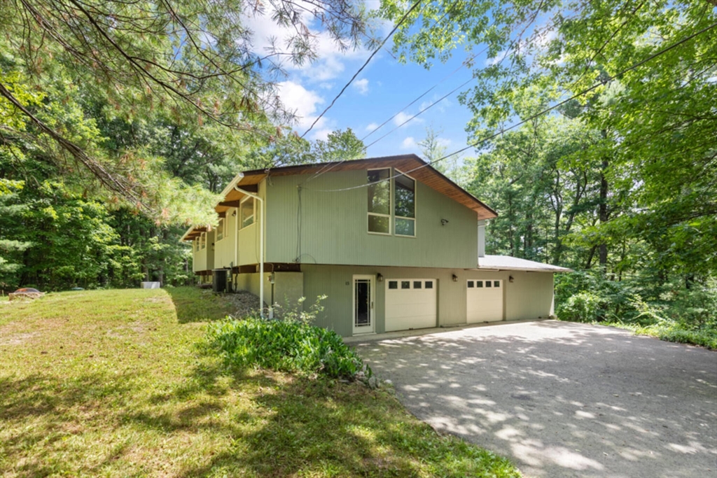 15 Pilgrims Path Sudbury, MA 01776 - Photo 27 of 29 a front view of a house with a yard and garage