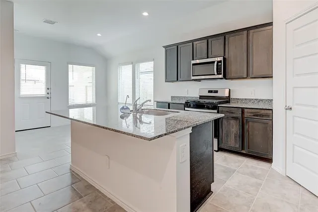 a kitchen with stainless steel appliances granite countertop a sink stove and microwave