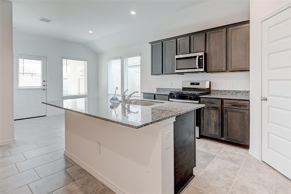 7502 Cynomys Court Rosharon, TX 77583 - Photo 3 of 10 a kitchen with stainless steel appliances granite countertop a sink stove and microwave