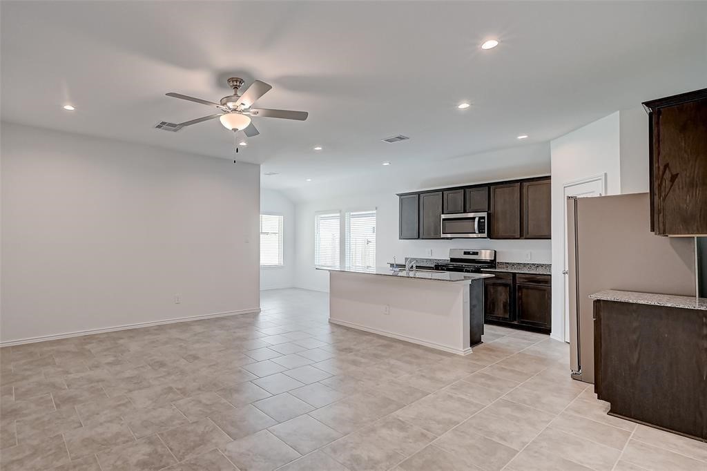 7502 Cynomys Court Rosharon, TX 77583 - Photo 4 of 10 a large kitchen with cabinets and stainless steel appliances