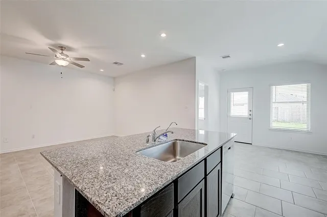 a kitchen with a sink a faucet cabinets and chandelier