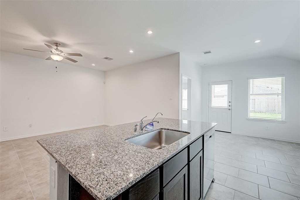 7502 Cynomys Court Rosharon, TX 77583 - Photo 5 of 10 a kitchen with a sink a faucet cabinets and chandelier