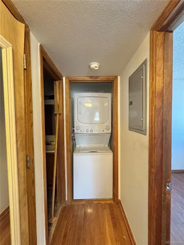 a view of a hallway with wooden floor and a kitchen