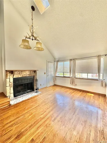 a view of empty room with wooden floor and fireplace